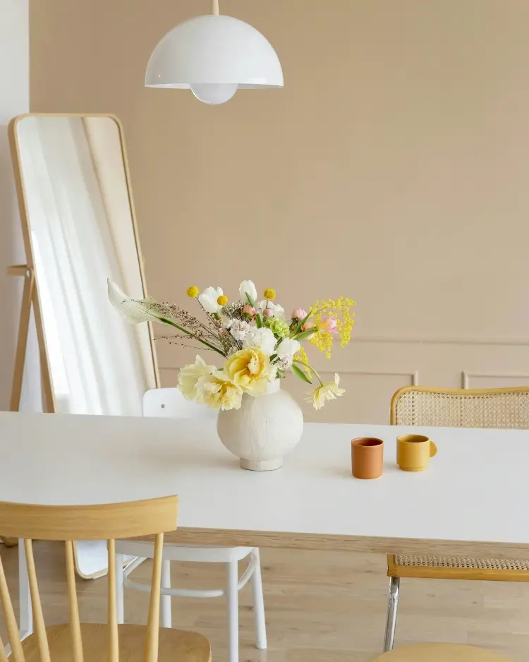 A flower pot sitting on a clean table in a room that has a neutral color palette and clean lines